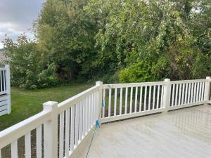 a white fence on top of a wooden deck at 3 Bedroom Lodge - Willows 24, Trecco Bay in Newton