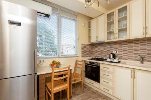 a kitchen with a refrigerator and a table and chairs at Prime location Apartment with Three Bedroom in Tbilisi City