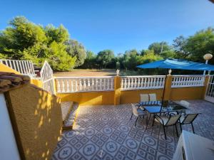 einen Balkon mit einem Tisch und einem blauen Sonnenschirm in der Unterkunft VILLA ARTEP Lujoso apartamento con piscina comunitaria in Cartagena