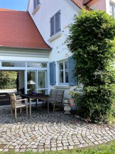 dom z patio ze stołem i krzesłami w obiekcie Sonnige Wohnung mit Garten am fränkischen Seenland w mieście Kammerstein