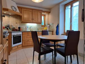 een keuken met een tafel en stoelen. bij Charmante maison individuelle in Les Verrières