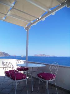 a table and chairs with a view of the ocean at Vlichos Studio Apartment in Hydra