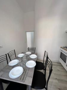 een eettafel met witte borden en stoelen bij Campo de’ Fiori Rooftop Apartment in Rome