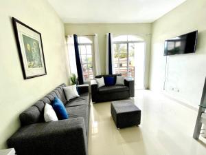uma sala de estar com um sofá e duas cadeiras em Balcón Skyline 2 em Jarabacoa