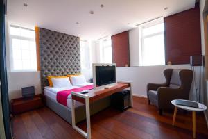 1 dormitorio con 1 cama y escritorio con TV en Boutique Rooms, en Belgrado