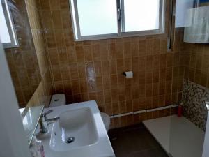 uma casa de banho com um lavatório, um WC e uma janela. em CASa CUBELa- Refugio en Sanxenxo em Bordons