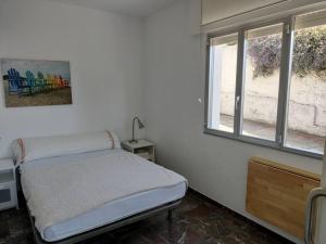 um quarto com uma cama e duas janelas em CASa CUBELa- Refugio en Sanxenxo em Bordons