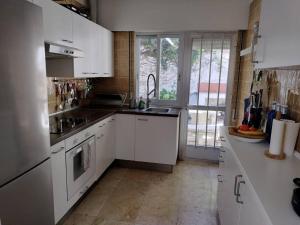 uma cozinha com armários brancos e uma grande janela em CASa CUBELa- Refugio en Sanxenxo em Bordons