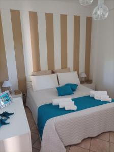 a bedroom with a large bed with two towels on it at ACasammare Apartment in Marsala