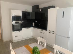 a kitchen with white appliances and a table with a plant at Nebřehovická, Strakonice. in Strakonice