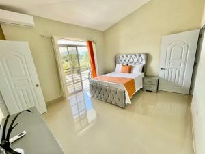 1 dormitorio con cama y ventana grande en Balcón Skyline 2, en Jarabacoa