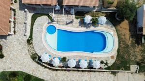 einen Blick über einen Pool mit Stühlen und ein Resort in der Unterkunft Vila Milo in Himarë