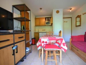 a kitchen with a table with a red table cloth on it at Appartement Flumet, 2 pièces, 4 personnes - FR-1-505-69 in Flumet