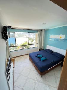 a bedroom with a bed and a large window at Edificio El Peñon del Rodadero Apartamento Playa Rodadero in Santa Marta +30 photos