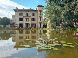 un bâtiment et un étang avec des nénuphars devant lui dans l'établissement Domaine de Marchal - chambres et table d'hôtes, à Celles-sur-Durolle