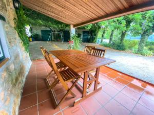 un tavolo e sedie in legno su un patio di Casa do Crasto ad Amarante