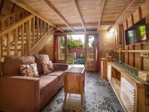 a living room of a log cabin with a couch and a table at Wisnu Lumbung Uluwatu in Uluwatu