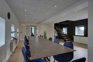 una sala conferenze con un lungo tavolo e sedie blu di 9 Rooms Amazing Sommerhouse a Børkop