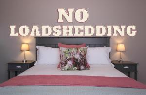 a bedroom with a bed with a no loading sign on the wall at Brookshill - Protea suite in Somerset West