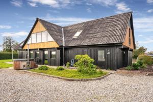 a black house with a black roof at Stor villa til 16 gæster Sauna & vildmarksbad 200 m strand in Børkop