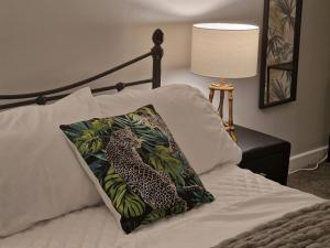 uma cama com uma almofada de leopardo em cima em 4 bed charming, Family-friendly cottage 1694 em Rossendale
