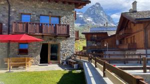 un edificio in pietra con una montagna sullo sfondo di Maison Carrel Elegant 2 a Breuil-Cervinia