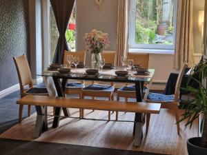 a dining room table and chairs with a table and a bench at 4 bed charming, Family-friendly cottage 1694 in Rossendale
