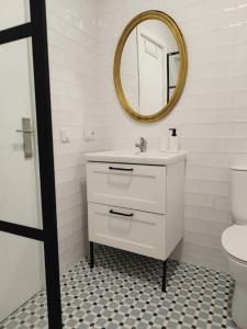 a white bathroom with a sink and a mirror at Balcón de Aguilar in Aguilar de la Frontera