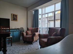 a living room with two chairs and a window at Balcón de Aguilar in Aguilar de la Frontera