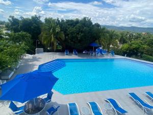 a large swimming pool with chairs and an umbrella at Apartamento en el penon 5 alcobas 7 baños in Girardot