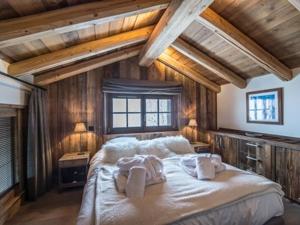 ein Schlafzimmer mit einem großen Bett mit Handtüchern darauf in der Unterkunft Chalet chaleureux familial avec spa, sauna et proche pistes à Méribel Village. - FR-1-566-24 in Les Allues