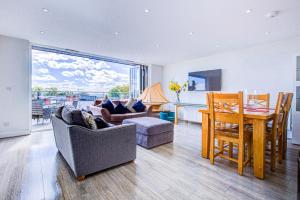 a living room with a table and a dining room at leigh Penthouse Apartment in Leigh-on-Sea