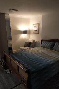 a bedroom with a bed and a chair in it at Leamington Park Studio with Parking in London