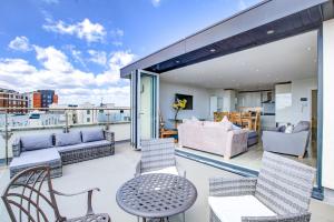 a balcony with a couch and chairs and a table at leigh Penthouse Apartment in Leigh-on-Sea