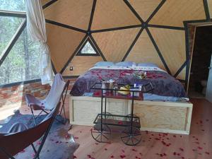 a bedroom in a tent with a bed and a chair at Glamping Town in Otinapa