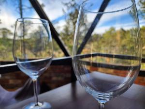 dwa kieliszki wina siedzące na stole w obiekcie Glamping Town w mieście Otinapa