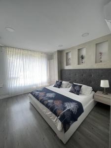 ein Schlafzimmer mit einem großen Bett in einem Zimmer mit Fenstern in der Unterkunft Edificio Lotus Loft in Cali