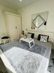 een slaapkamer met een groot bed en een tafel. bij Baltijos apartamentai in Klaipėda