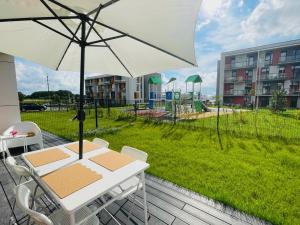 a table and chairs with an umbrella on a deck at Baltijos apartamentai in Klaipėda