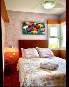 1 dormitorio con 1 cama con una pintura en la pared en No Centro de Gramado em condomínio encantador, en Gramado
