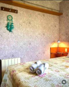 Un dormitorio con una cama con almohadas blancas. en No Centro de Gramado em condomínio encantador, en Gramado