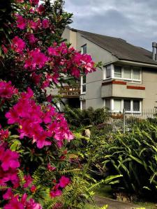 una casa con flores rosas delante de ella en No Centro de Gramado em condomínio encantador, en Gramado