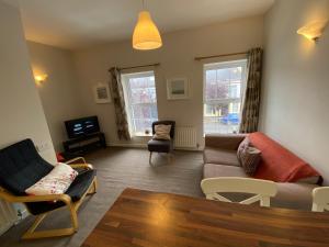 a living room with a couch and chairs at Irvinestown Fermanagh 2 Bedroom Apartment in Irvinestown