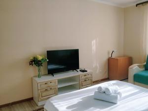a living room with a tv and a table with towels at EmmaApart Comfort 110 in Astana