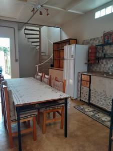 a dining room with a table and a refrigerator at Casa Topázio no Container dos Cristais in Delfinópolis