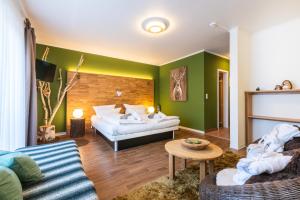 - un salon avec un lit et un canapé dans l'établissement Hotel Ziegelruh, à Babenhausen