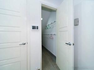 un couloir blanc avec deux portes blanches et une chambre dans l'établissement Cozy Modern Brooklyn Apartment w/ Balcony, à Brooklyn