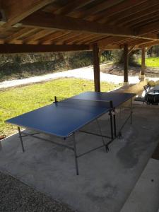 una mesa de ping pong azul sentada bajo un pabellón en Le Moulin de la Borie en Belfort-du-Quercy