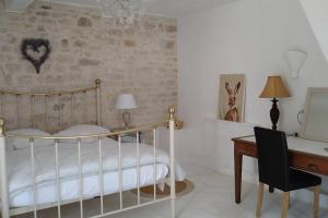 a bedroom with a bed and a desk and a chair at Le Moulin de la Borie in Belfort-du-Quercy