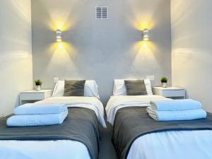 2 camas en una habitación con luces en la pared en WHITE DREAM Near the Sea 3bed by Solrentspain, en Mijas Costa